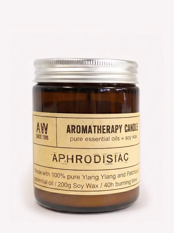 Amber jar Aphrodisiac Ylang Ylang soy candle with silver lid and cream label.
