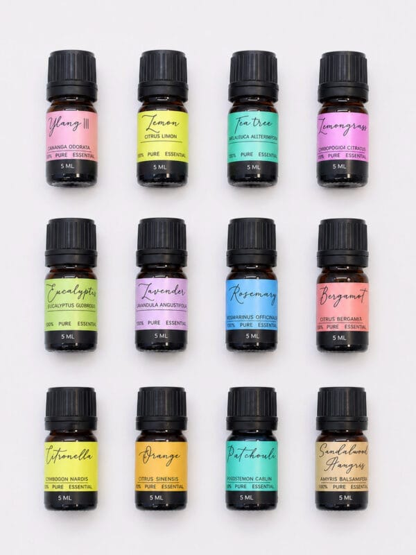 Set of 12 small amber essential oil bottles with black caps and colourful labels arranged in a neat grid.