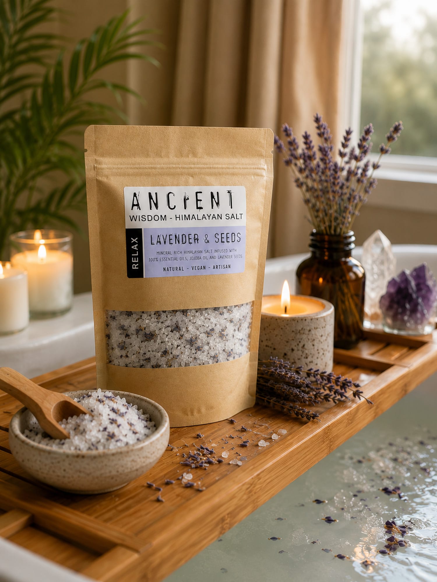 Lavender Moon Himalayan bath salts on bath tray with bowl, wooden scoop, candle and lavender sprigs by the tub.
