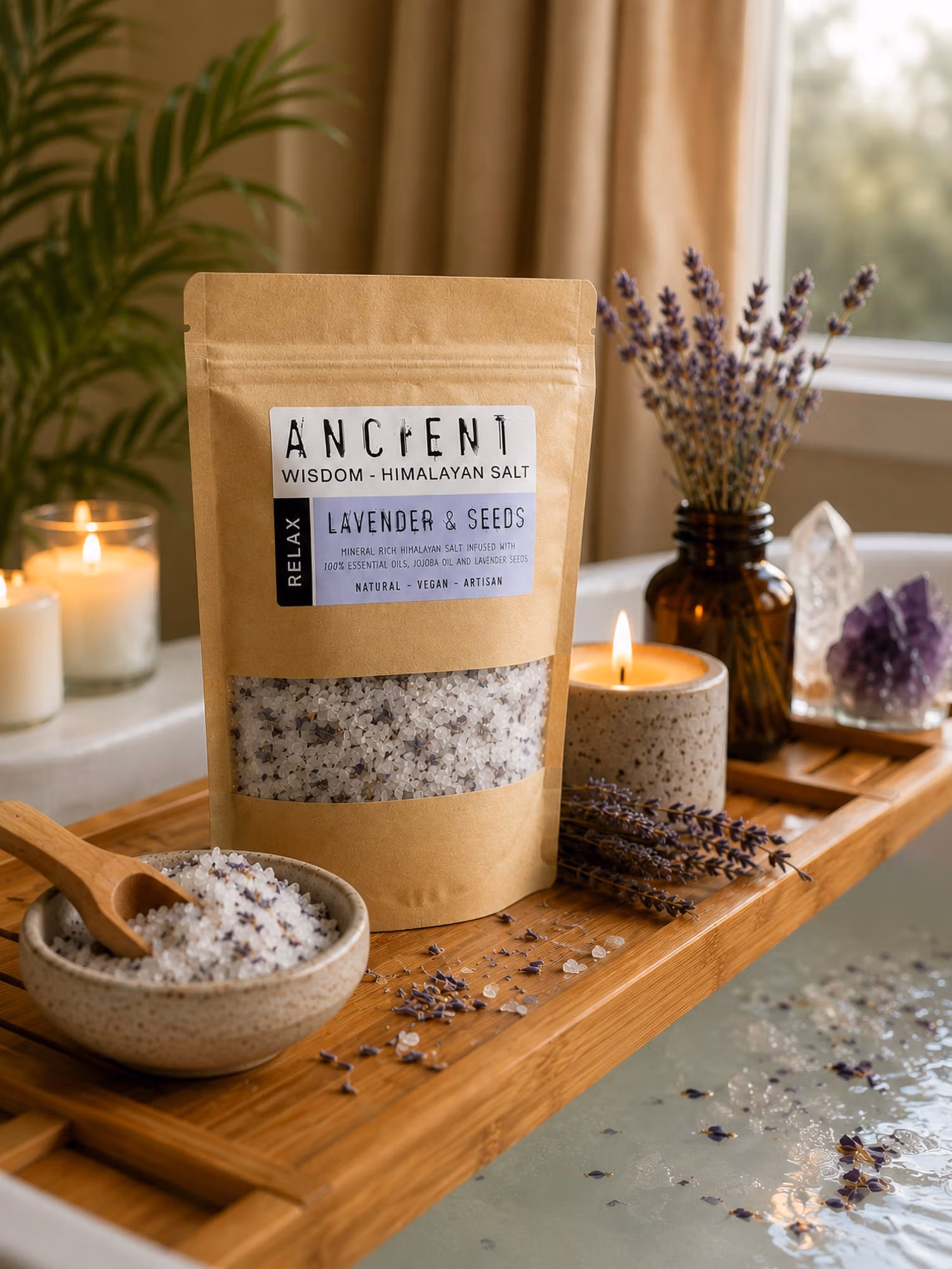 Lavender Moon Himalayan bath salts on bath tray with bowl, wooden scoop, candle and lavender sprigs by the tub.