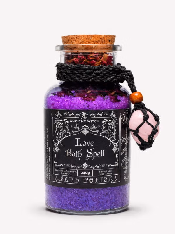 Love Bath Ritual jar filled with purple bath salts and dried roses, with rose quartz amulet tied around the neck.