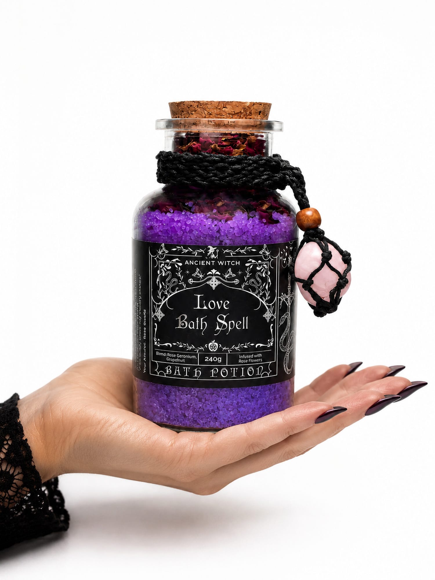 Hand supporting Love Bath Ritual jar with purple salts and rose quartz amulet, showing its size.