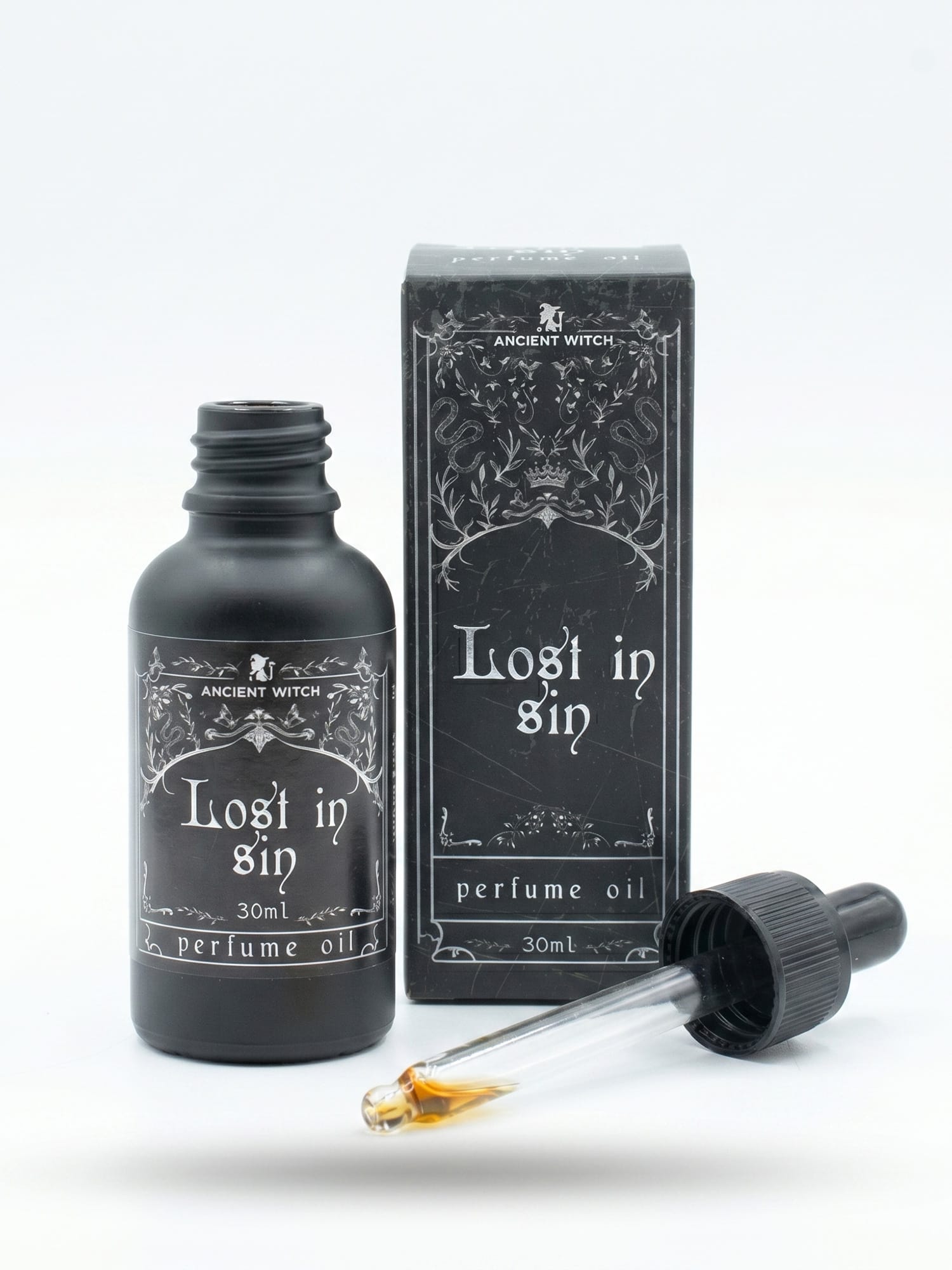 Open Lost in Sin perfume oil bottle with dropper pipette and ornate box behind.