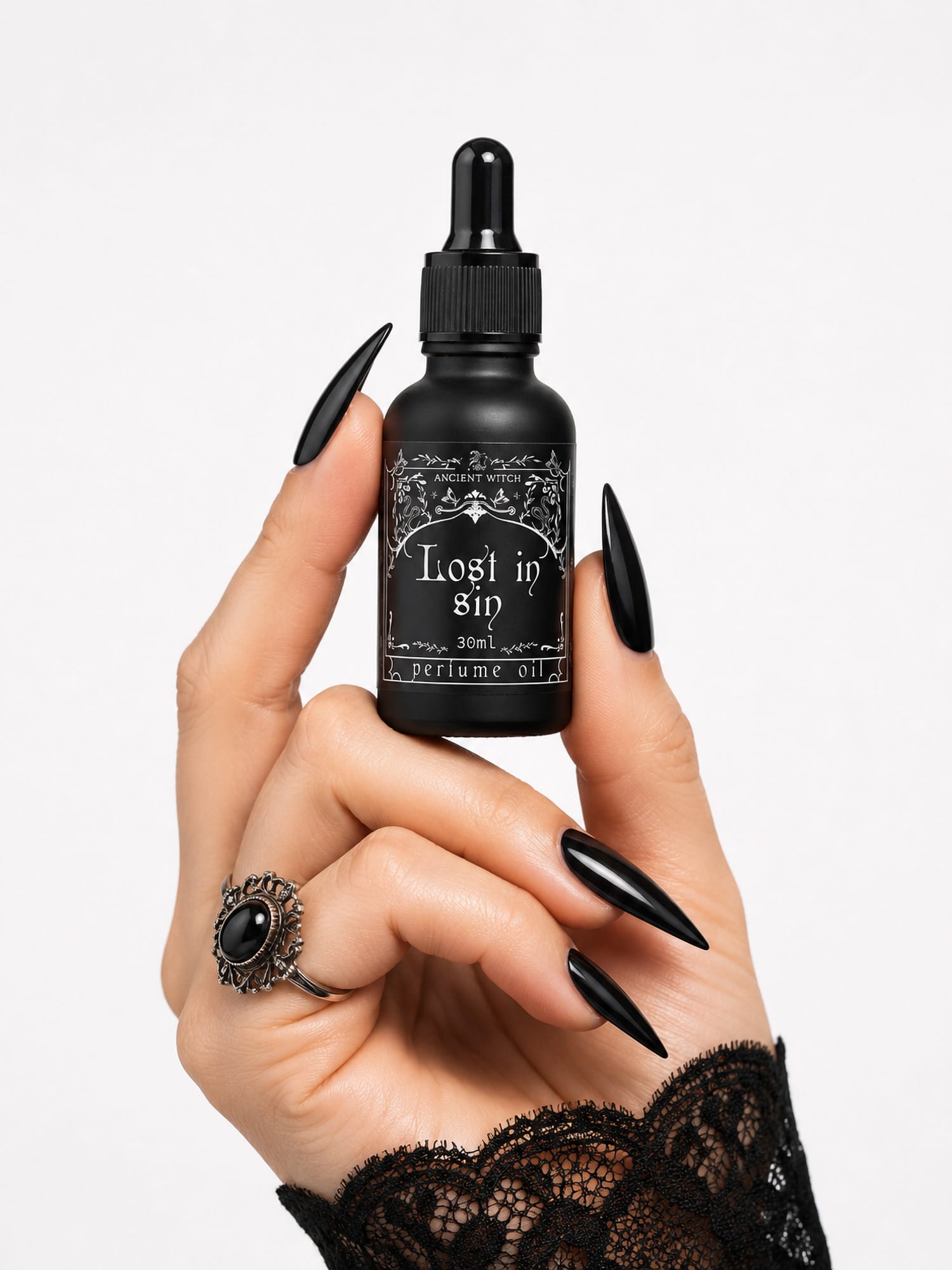 Hand with black nails holds Lost in Sin perfume oil bottle to show size.