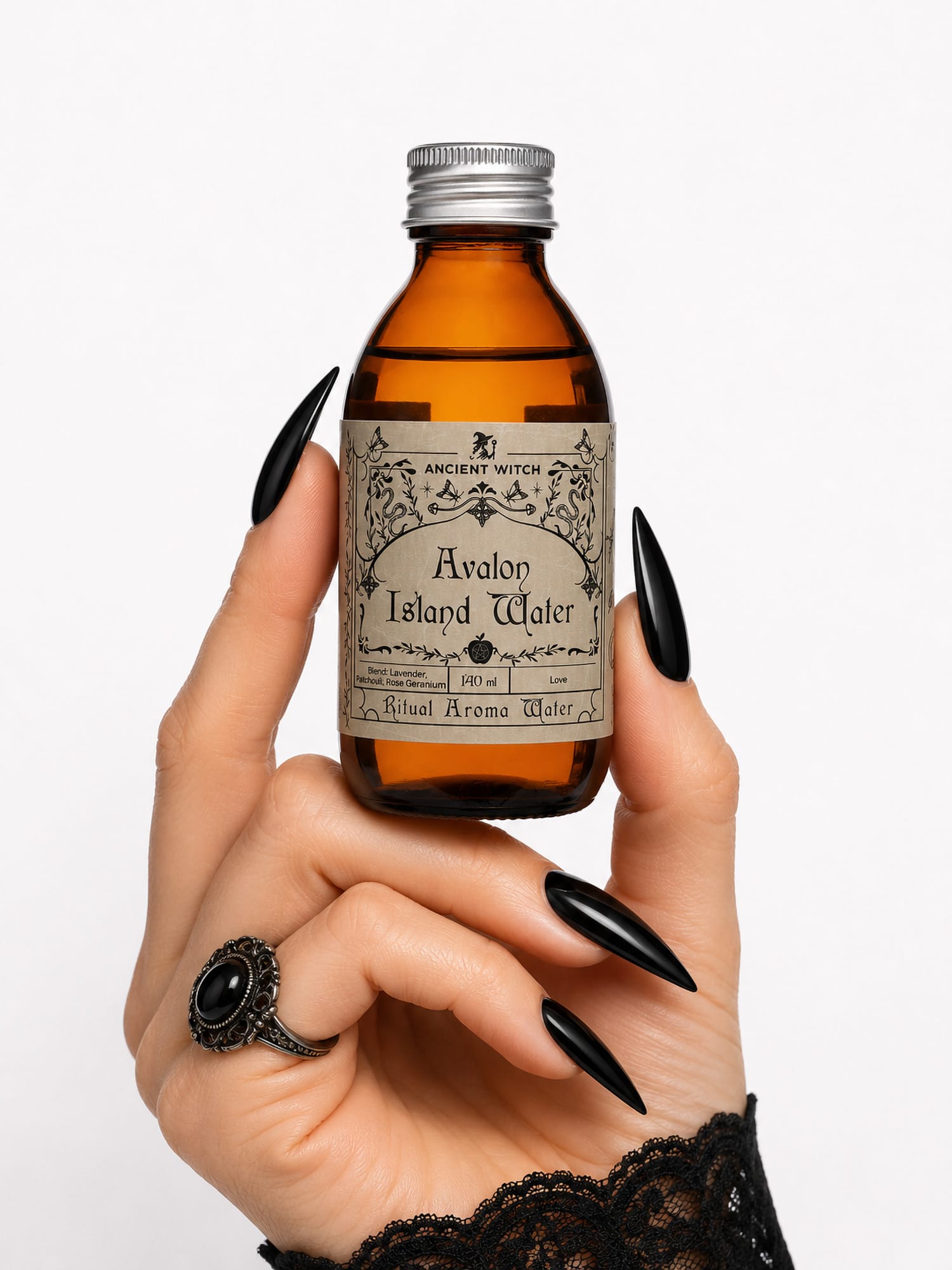 Hand with black nails holds Avalon Island ritual water bottle for scale.