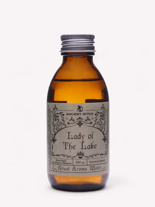Lady of the Lake ritual water amber bottle with silver cap and ornate label.