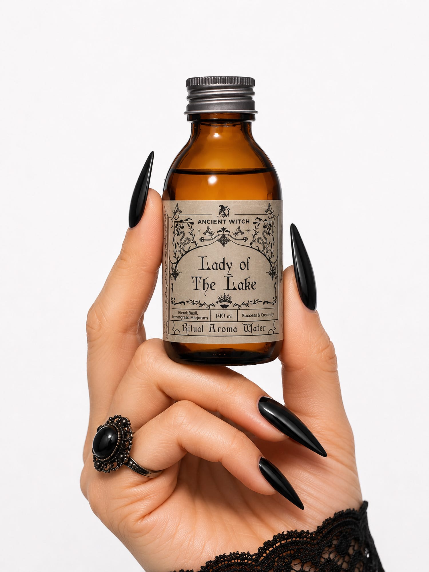 Hand with black nails holds Lady of the Lake ritual water bottle for scale.