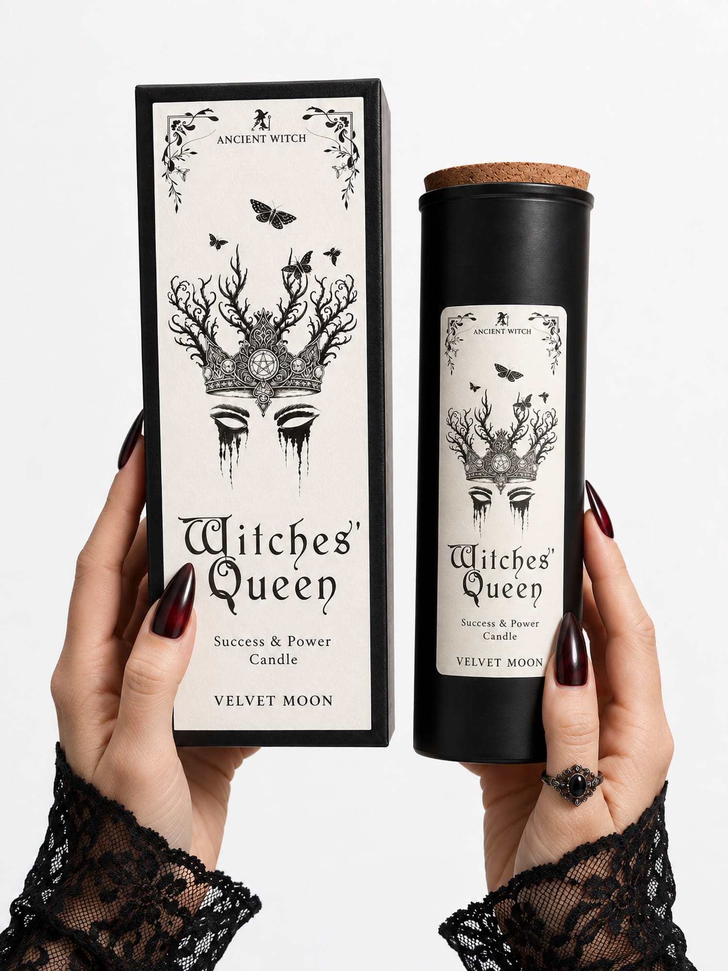 Hands with dark nails holding the Witches’ Queen ritual candle and tall gift box to show their size.