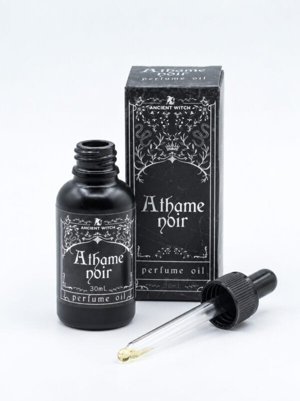 Open 30ml bottle of Athame Noir perfume oil with its glass dropper and black presentation box on a white background.