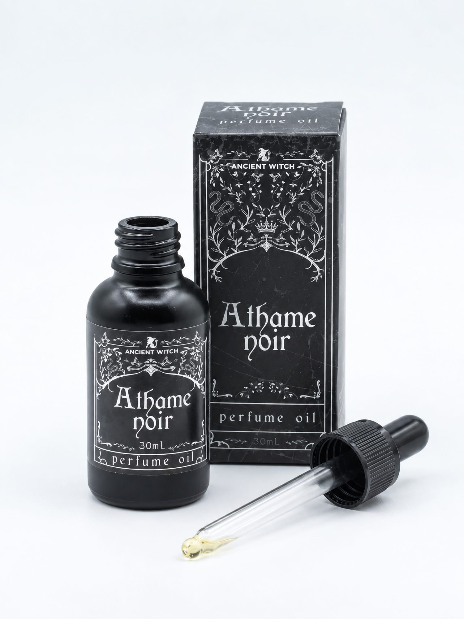 Open 30ml bottle of Athame Noir perfume oil with its glass dropper and black presentation box on a white background.