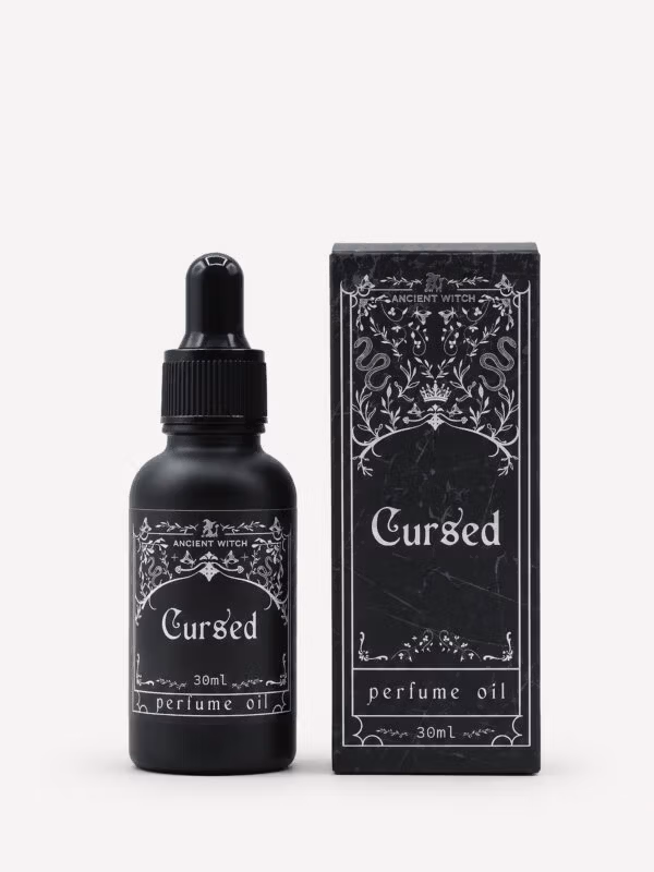 Ancient Witch Cursed perfume oil in a black 30ml dropper bottle beside its ornate black gift box.